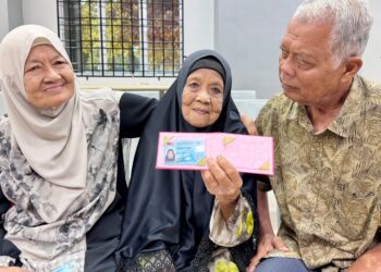 BEDAH Salleh (tengah) di samping anak-anaknya, Sopeah Majid dan Ghazali Majid selepas menerima MyKad Generasi Baharu sempena sambutan Hari JPN di Pejabat JPN Kedah, Anak Bukit di Alor Setar, Kedah hari ini.
