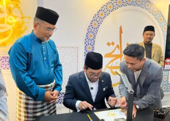 ZULKIFLI Hasan menunjukkan kemahiran penulisan seni khat selepas merasmikan Pameran Seni Khat Sedunia sempena Majlis Tilawah dan Hafazan al-Quran Peringkat Antarabangsa (MTHQA) Ke-66 di Pusat Dagangan Dunia Kuala Lumpur, hari ini. - UTUSAN/MADZALINA MAJING