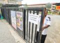 SEORANG pengawal keselamatan menutup pagar yang telah ditampal notis penutupan sekolah akibat jerebu di SMK Bandar Baru Uda, Johor Bahru, Johor, semalam. – UTUSAN/RAJA JAAFAR ALI