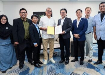 Joniston Bangkuai menerima memorandum cadangan tujuh perkara disampaikan Pengerusi KREATIF SABAH, Chester Pang. - UTUSAN/HARDY JOE