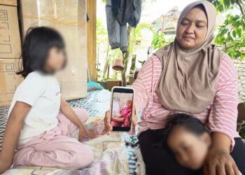 MARLIZA Ibrahim bersama dua anak Allahyarham Norhazwani menunjukkan gambar arwah ketika ditemui di rumahnya di Kampung Banjir, Telaga Bata, Pengkalan Kubor, Tumpat, Kelantan hari ini.