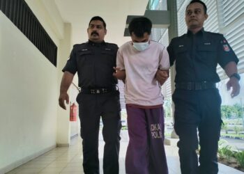 TERTUDUH semasa dibawa polis untuk prosiding pertuduhan di Mahkamah Majistret Pasir Mas, Kelantan hari ini-UTUSAN/ROHANA ISMAIL.