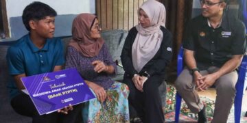 NORLIZA Abdul Rahim (dua dari kanan) berbual dengan keluarga Muhammad Farish Mohamad Fadzil (kiri) ketika menyampaikan dokumen tawaran Biasiswa Anak eKasih PTPTN (BAeK PTPTN). – UTUSAN/DANIAL SAAD