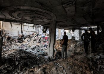 ORANG ramai memeriksa runtuhan bangunan yang rosak teruk selepas serangan Israel ke atas sebuah apartmen kediaman di kawasan Rimal, Bandar Gaza. - AFP