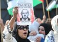 SEORANG penunjuk perasaan mengangkat poster memaparkan Perdana Menteri Israel, Benjamin Netanyahu, sebagai individu 'dikehendaki' semasa protes solidariti Palestin di Berlin, Ogos tahun lalu.- AFP