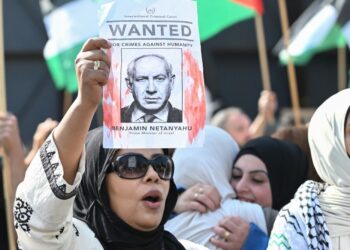 SEORANG penunjuk perasaan mengangkat poster memaparkan Perdana Menteri Israel, Benjamin Netanyahu, sebagai individu 'dikehendaki' semasa protes solidariti Palestin di Berlin, Ogos tahun lalu.- AFP