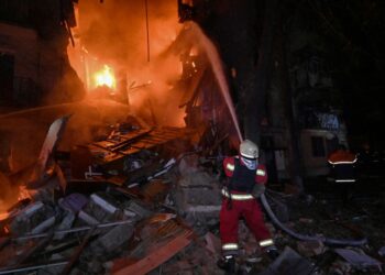 ANGGOTA bomba memadamkan kebakaran di lokasi serangan dron Russia yang menyasarkan sebuah bangunan kediaman bertingkat di Kharkiv, Ukraine.  - AFP