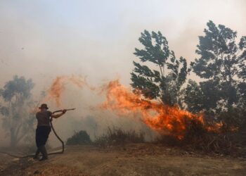 ANGGOTA bomba bergelut memadamkan kebakaran belukar yang merebak pantas di tengah kepulan asasp tebal di Tegal Arum, Banjarbaru, Kalimantan Selatan.- AFP