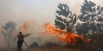 ANGGOTA bomba bergelut memadamkan kebakaran belukar yang merebak pantas di tengah kepulan asasp tebal di Tegal Arum, Banjarbaru, Kalimantan Selatan.- AFP