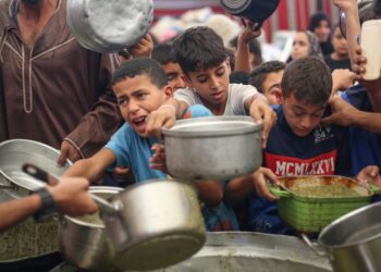PENDUDUK Palestin berebut untuk mendapatkan hidangan yang diagihkan oleh dapur amal di kem pelarian Nuseirat, di tengah Gaza.- AFP
