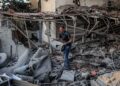 SEORANG lelaki membawa tong gas di celah runtuhan bangunan yang mengalami kerosakan teruk susulan serangan Israel ke atas sebuah pangsapuri kediaman di kawasan kejiranan Rimal, Gaza City, semalam.- AFP