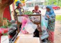 PENDUDUK kampung membeli barangan keperluan daripada Mat Junoh Latif, penjaja motosikal roda tiga di Kampung Penambang, Kota Bharu, Kelantan. – UTUSAN/ ROSLIZA MOHAMED
