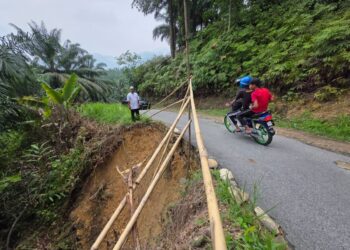 JALANI Rasid menunjukkan keadaan jalan yang rosak di Kampung Makmur, Hulu Kinta dekat Ipoh semalam. – UTUSAN/AIN SAFRE BIDIN