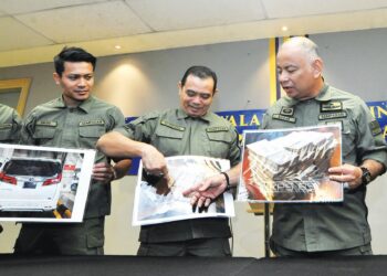 MOHD. NASARUDDIN M. Nasir (kanan) bersama pegawai AKPS menunjukkan gambar wang tunai yang dirampas hampir RM3 juta susulan penahanan dua warganegara di Johor Bahru semalam.