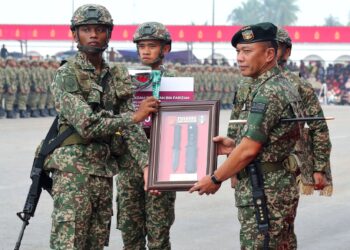 Malek Razak Sulaiman menyampaikan anugerah Perajurit Terbaik Keseluruhan kepada Muhammad Akram Syazwan Farizal pada Upacara Perbarisan Tamat Latihan Perajurit Muda Lelaki Siri 206/26 di Pusasda,  Negeri Sembilan semalam. -MINGGUAN/MOHD. SHAHJEHAN MAAMIN