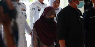 SAKINAH Ismail diiringi polis semasa tiba untuk prosiding perbicaraan di Mahkamah Majistret Kota Bharu, Kelantan. – UTUSAN/KAMARUL BISMI KAMARUZAMAN