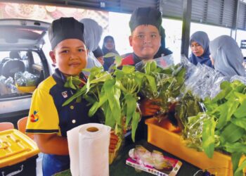 MURID-murid PPKI SK Simpang Ampat menunjukkan sayur-sayuran hidroponik yang dijual di pasar tani Simpang Ampat, Kangar, Perlis. – UTUSAN/ASYRAF MUHAMMAD