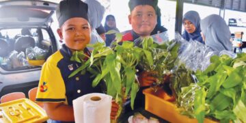 MURID-murid PPKI SK Simpang Ampat menunjukkan sayur-sayuran hidroponik yang dijual di pasar tani Simpang Ampat, Kangar, Perlis. – UTUSAN/ASYRAF MUHAMMAD