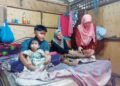SITI Hajar Abdullah menerima kunjungan Shahanim Mohamad Yusoff (kanan) sambil Muhammad Elias Bahari Maskeri memangku adik bongsunya di Kampung Bakar Kapor, Sungai Petani, Kedah semalam.