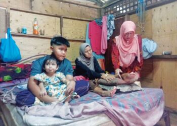 SITI Hajar Abdullah menerima kunjungan Shahanim Mohamad Yusoff (kanan) sambil Muhammad Elias Bahari Maskeri memangku adik bongsunya di Kampung Bakar Kapor, Sungai Petani, Kedah semalam.