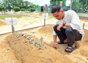 MOHAMMAD Amar Irfan Sabran menziarah kubur tunangnya,  Siti Nor Sazlin di Tanah Perkuburan Islam Kampung Air Hitam Labu, di Kampar semalam. – MINGGUAN/AIN SAFRE BIDIN