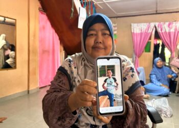 JUNAIDA Deraman menunjukkan gambar Allahyarham Al Zubair yang terlibat dalam kemalangan di Kampung Tok Sadang Kota Bharu, Kelantan. - UTUSAN/ ROSLIZA MOHAMED