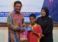 BADRUL Hisham Alias (dua dari kiri) menyerahkan Mykad Generasi Baharu kepada penghuni Taman Sinar Harapan pada Program MEKAR JPN Negeri Terengganu di Kuala Terengganu, Terengganu. - UTUSAN/PUQTRA HAIRRY