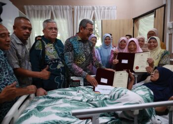 WAN Ahmad Dahlan Abdul Aziz (kiri) menyerahkan Sijil Penghargaan dan pesara kepada bekas gurunya,  Siti Zaitun Abdullahk ketika hadir di Pusat Jagaan ShalisCare Centre, Telipot, Kota Bharu, Kelantan. - UTUSAN/KAMARUL BISMI KAMARUZAMAN