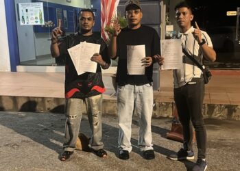 NORADLY Othman (kanan) menunjukkan laporan polis yang dibuat di Balai Polis Indera Mahkota di Kuantan, Pahang.