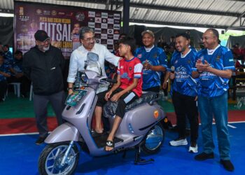 JOHARI Abdul Ghani ketika menyerahkan hadiah cabutan bertuah berupa motosikal elektrik pada Pesta Sukan Titiwangsa Futsal 2026 di SLK Sport Center, Mukim Batu, di sini hari ini. - UTUSAN/SYAKIR RADIN