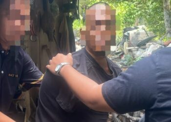 SUSPEK (tengah) semasa ditahan polis dalam serbuan di Pasir Puteh, Kelantan pagi tadi.