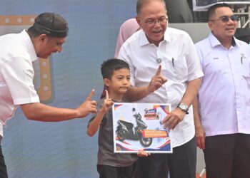 WAN ROSDY Wan Ismail (dua dari kiri), menyampaikan hadiah motosikal kepada kanak-kanak yang memenangi cabutan bertuah, pada majlis Aspirasi Pahang First Daerah Kuantan di Kuantan, Pahang. - FOTO/SHAIKH AHMAD RAZIF