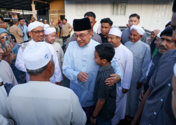 ANWAR Ibrahim (kiri) beramah mesra dengan warga Madrasah Ar-Rahmaniah Ad-Diniah Pondok Lubok Tapah, Pasir Mas, Kelantan sebentar tadi.-UTUSAN/KAMARUL BISMI KAMARUZAMAN