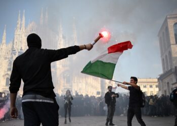 PENUNJUK perasaan menyalakan suar ketika menyertai demonstrasi antikerajaan di Piazza Duomo di Milan, Itali. -AFP