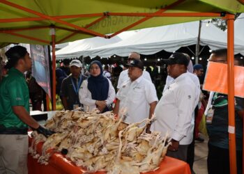 FAISAL Iswardi Ismail (dua dari kanan) bertanya khabar peniaga semasa program Jualan Agro Madani (JAM) Mega Terengganu di Dataran Shahbandar, Kuala Terengganu, Terengganu. - UTUSAN/PUQTRA HAIRRY