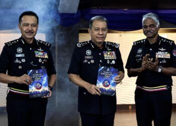 MOHD. Khalid Ismail (tengah) bergambar bersama buku Panduan Jururunding PDRM pada Majlis Pelancarannya di Mes Pegawai Kanan Bukit Aman semalam.-BERNAMA.