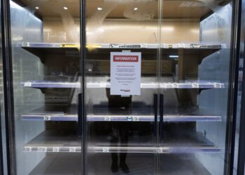 NOTIS yang dipaparkan pada peti sejuk makanan segar yang kosong di sebuah pasar raya Intermarche di Nevez. - AFP