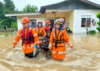 ANGGOTA Angkatan Pertahanan Awam (APM) Daerah Yan membantu memindahkan seorang warga emas yang terjejas banjir di Yan.