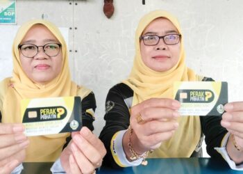 ROZIAH Saleh (kiri) bersama Norimah Amir Husin menunjukkan Kad Perak Sejahtera, berupa bantuan RM100 sebulan untuk membeli makanan asas yang diberi bawah program Perak Sejahtera 2030. 
– UTUSAN/WAT KAMAL ABAS