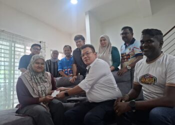 SHUHAIMI Mohamed (tengah) menyampaikan sumbangan kewangan daripada Ahmad Zahid Hamidi ketika mengunjungi kediaman Zahratulhayat Mat Arif di Medan Klebang Harmoni 2, Chemor, Ipoh hari ini.
