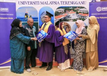 Muhammad Afham Saipulismi (tiga dari kiri) dan Nur Hanis Afiqah Adnan (tiga dari kanan) bersama ahli keluarga selepas Majlis Istiadat Konvokesyen UMT ke-24 di Dewan Sultan Mizan,  Gong Badak, Kuala Nerus, Terengganu. – UTUSAN/PUQTRA HAIRRY