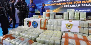 ANGGOTA polis berkawal di sisi bungkusan dadah yang dirampas pada sidang media di Belawan, Medan, wilayah Sumatera Utara. - AFP