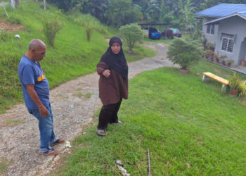 MOHD. Amin Nupah (kiri) bersama seorang penduduk di lokasi kejadian anggota polis dibelasah warga Myanmar di Kampung Pamah Kulat, Raub, Pahang.