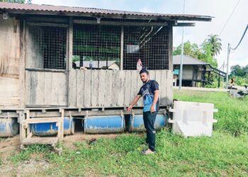MUHAMMAD Aslam Mi Hamidi menunjukkan tong dipasang untuk mengapungkan rumahnya ketika banjir di Kampung Pagi, Ulu Tembeling, Jerantut, Pahang. – UTUSAN/HARIS FADILAH AHMAD