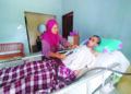 ROSLIZA Wahid menguruskan Tawaka Ab. Ghani yang terlantar selepas terkena jangkitan kuman pada selaput otak di Kampung Bukit Jeruk, Besut, Terengganu. – UTUSAN/WAN ZURATIKAH IFFAH WAN ZULKIFLI