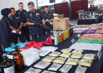 DENNIS Lim Kwang Keng (empat dari kiri) menunjukkan sebahagian daripada dadah serta peralatan yang digunakan untuk memproses barang terlarang itu yang dirampas dalam tiga operasi berasingan ketika sidang akhbar di George Town, Pulau Pinang hari ini.-UTUSAN/DANIAL SAAD