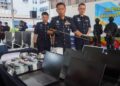 DENNIS Lim Kwang Keng (tengah) menunjukkan sebahagian daripada barangan yang dirampas susulan serbuan ke atas tiga buah banglo yang dipercayai menjalankan sindiket penipuan gores dan menang ketika sidang akhbar di George Town, Pulau Pinang hari ini. - UTUSAN/DANIAL SAAD