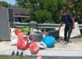 P. SIVANESWARAN membuang peralatan elektrik yang rosak akibat banjir kilat yang melanda rumahnya di Jalan Kolam Ayer, Taman Nong Chik, Johor Bahru.