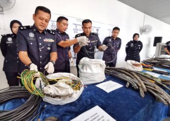 OHARI Yahya (kiri) menunjukkan gulungan kabel dan jalur tembaga konduktor kilat yang dirampas semasa sidang akhbar di IPD Nilai, Seremban hari ini.-UTUSAN/MOHD. SHAHJEHAN MAAMIN