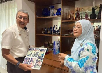 WAN Ahmad Dahlan (kiri) menyantuni bekas guru Bahasa Melayunya, Nik Aziah Wan Hamzah (kanan) menerusi Program Santuni Pesara di sini, hari ini.